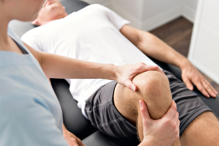 Physiotherapist treating a mans knee, for Sarah Lord Physiotherapy and Wellbeing