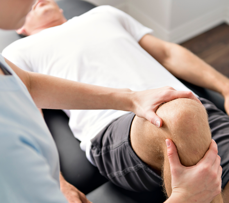 Physiotherapist treating a mans knee