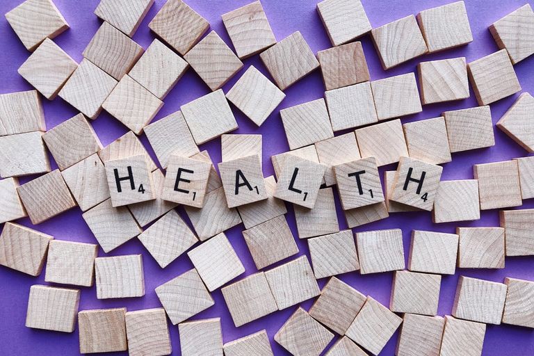 The word 'Health' written in scrabble tiles laid on top of blank tiles with a purple background, for Sarah Lord Physiotherapy and Wellbeing