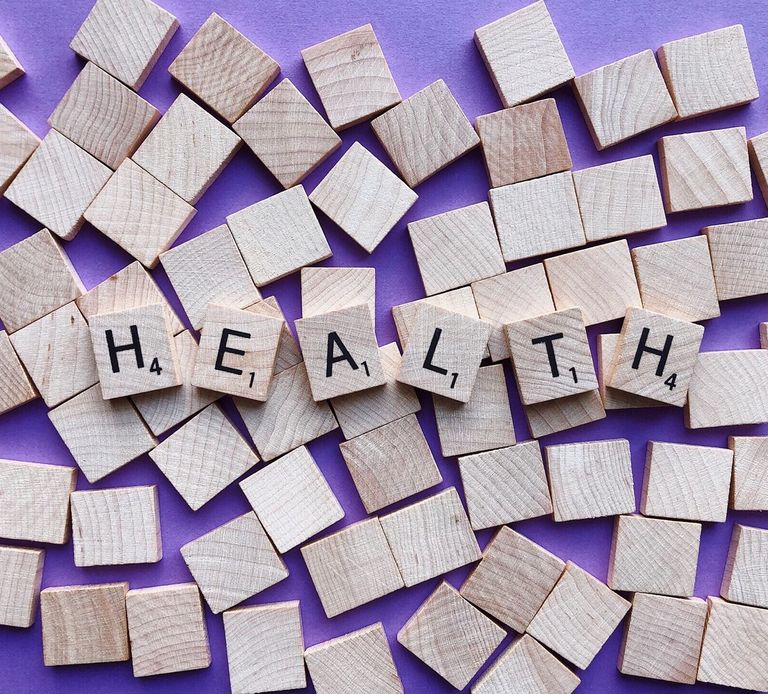 The word 'Health' written in scrabble tiles laid on top of blank tiles with a purple background, for Sarah Lord Physiotherapy and Wellbeing